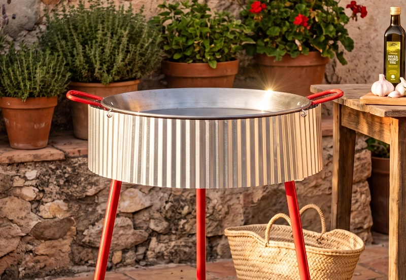 Paravientos universal colgado del borde de la paella